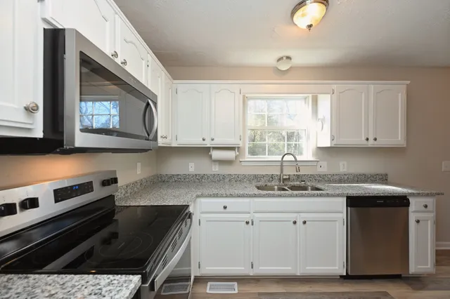 a kitchen with a sink stove and cabinets