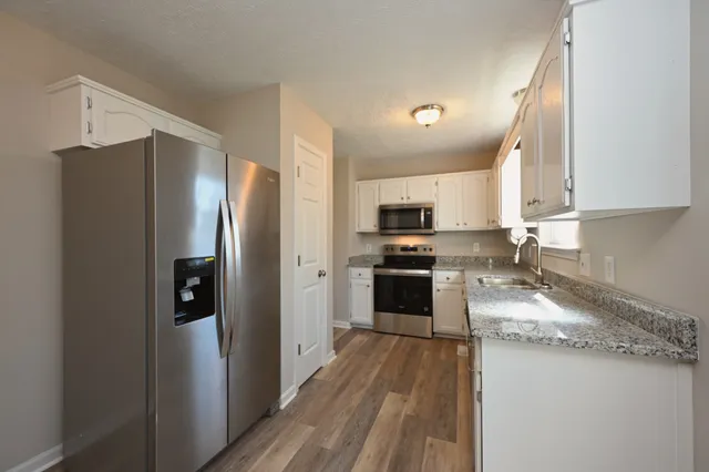 a kitchen with stainless steel appliances granite countertop a refrigerator and a sink
