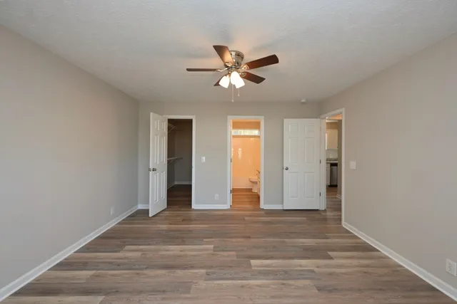 a view of a livingroom with a chandelier fan and wooden floor