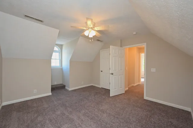 an empty room with closet and a ceiling fan