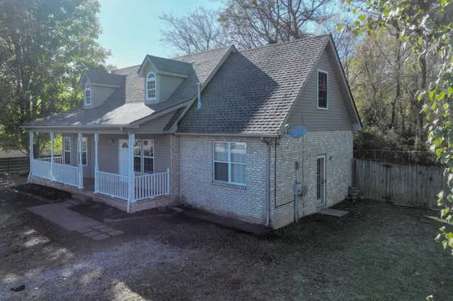 a view of a house with a yard and wooden fence