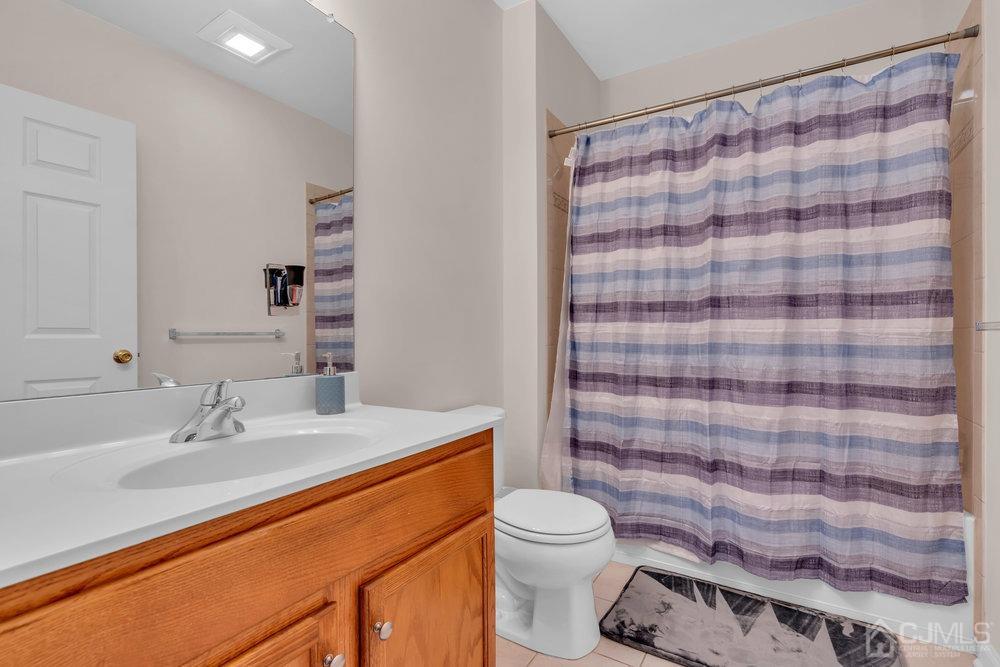 368 Rector Street, Unit 508 Perth Amboy, NJ 08861 - Photo 13 of 34 a bathroom with a sink a toilet a shower curtain and a large mirror