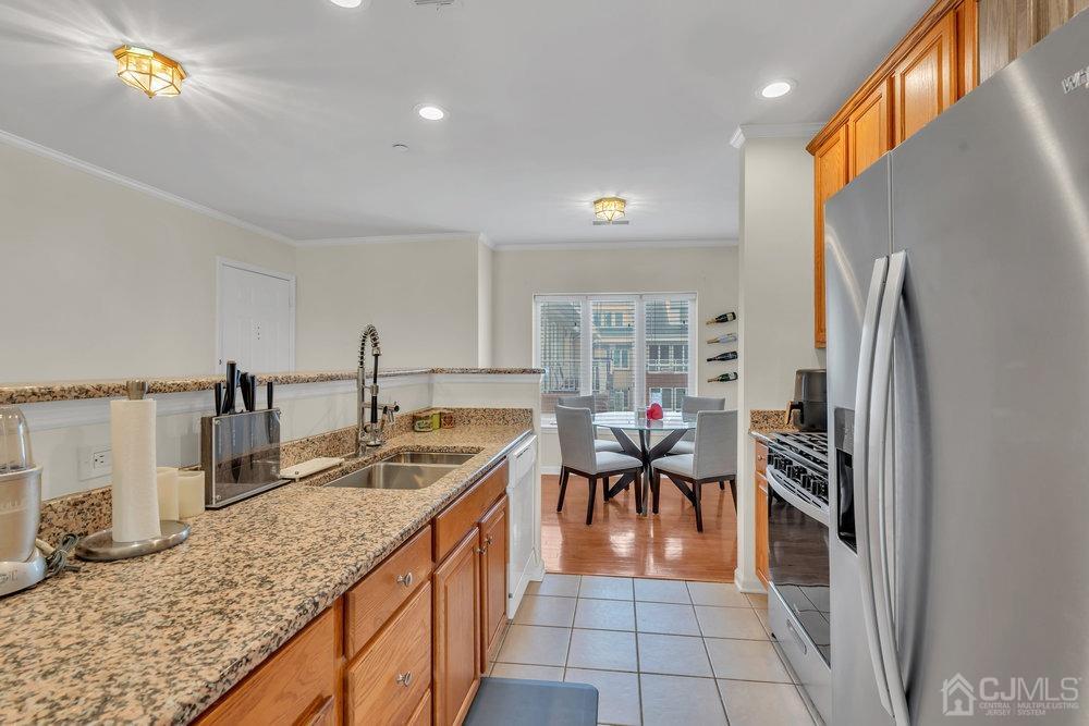 368 Rector Street, Unit 508 Perth Amboy, NJ 08861 - Photo 26 of 34 a kitchen with granite countertop a sink and a refrigerator