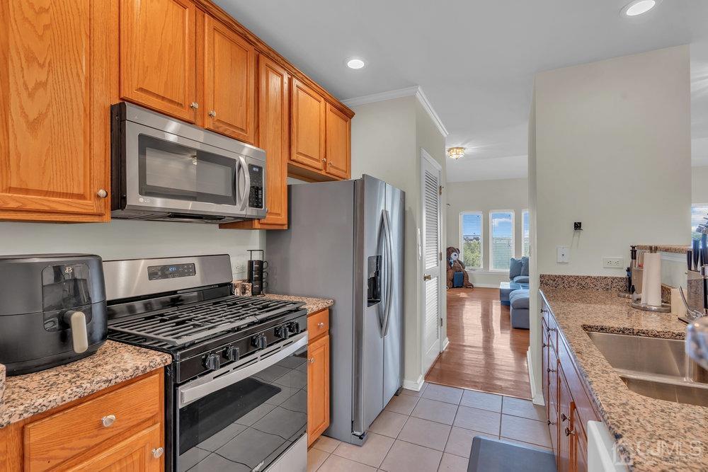 368 Rector Street, Unit 508 Perth Amboy, NJ 08861 - Photo 28 of 34 a kitchen with stainless steel appliances granite countertop a stove a refrigerator and a microwave