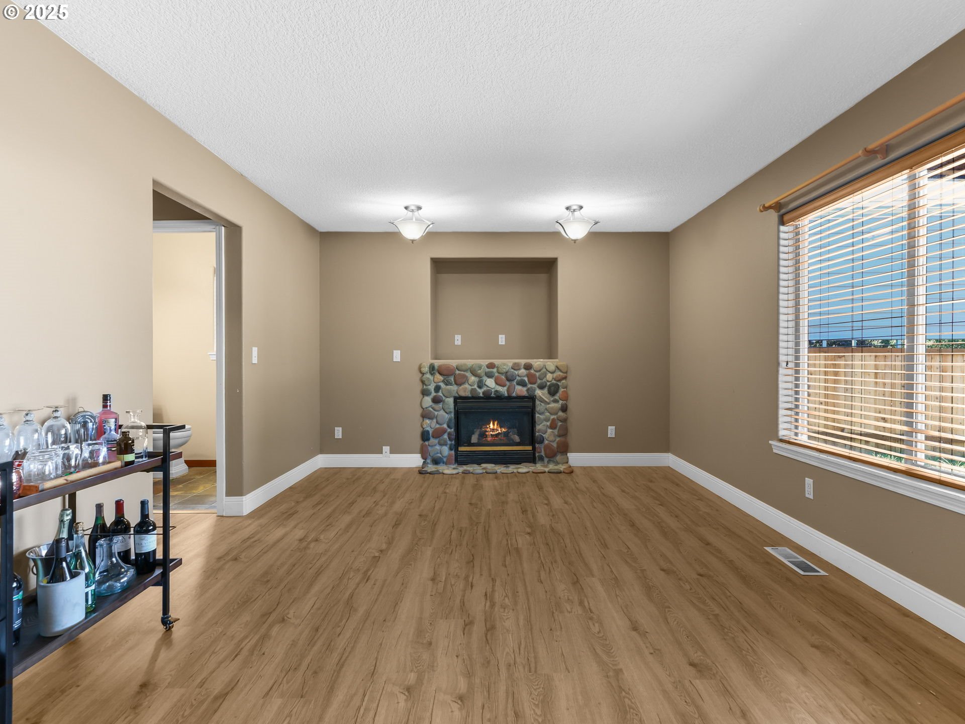 52407 Northeast 14th Scappoose, OR 97056 - Photo 11 of 46 a view of an empty room with wooden floor fireplace and a window