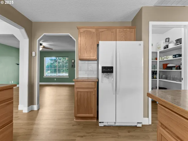 a kitchen with a refrigerator a stove and a sink with wooden floor