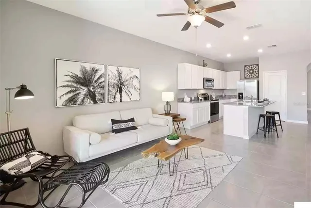 a living room with furniture and kitchen view