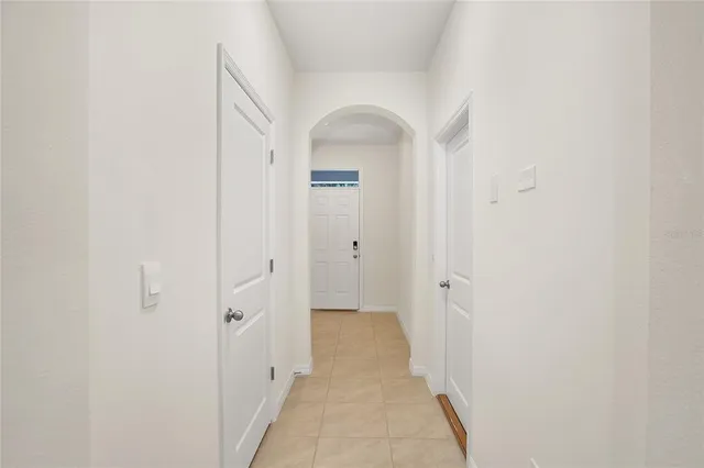 a view of a hallway with wooden floor and a bathroom