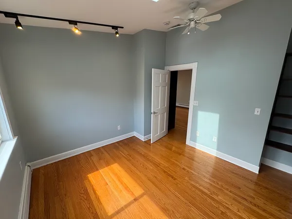 a view of empty room with wooden floor