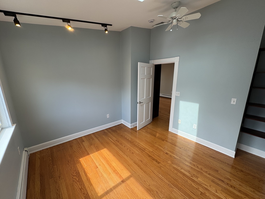 24 Ellington Road, Unit 3 Somerville, MA 02144 - Photo 13 of 21 a view of an empty room with wooden floor and cabinet