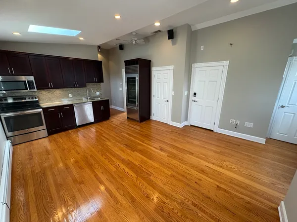 a large kitchen with stainless steel appliances a large counter top
