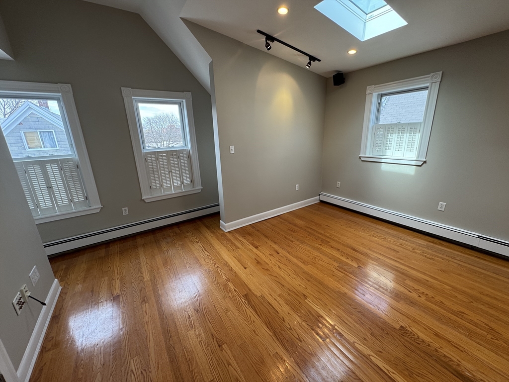 24 Ellington Road, Unit 3 Somerville, MA 02144 - Photo 4 of 21 a view of an empty room with wooden floor and a window