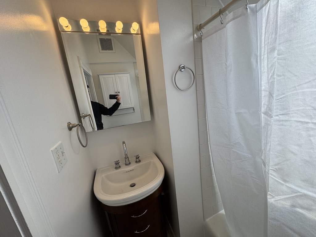 24 Ellington Road, Unit 3 Somerville, MA 02144 - Photo 10 of 21 a bathroom with a sink a mirror a vanity and shower