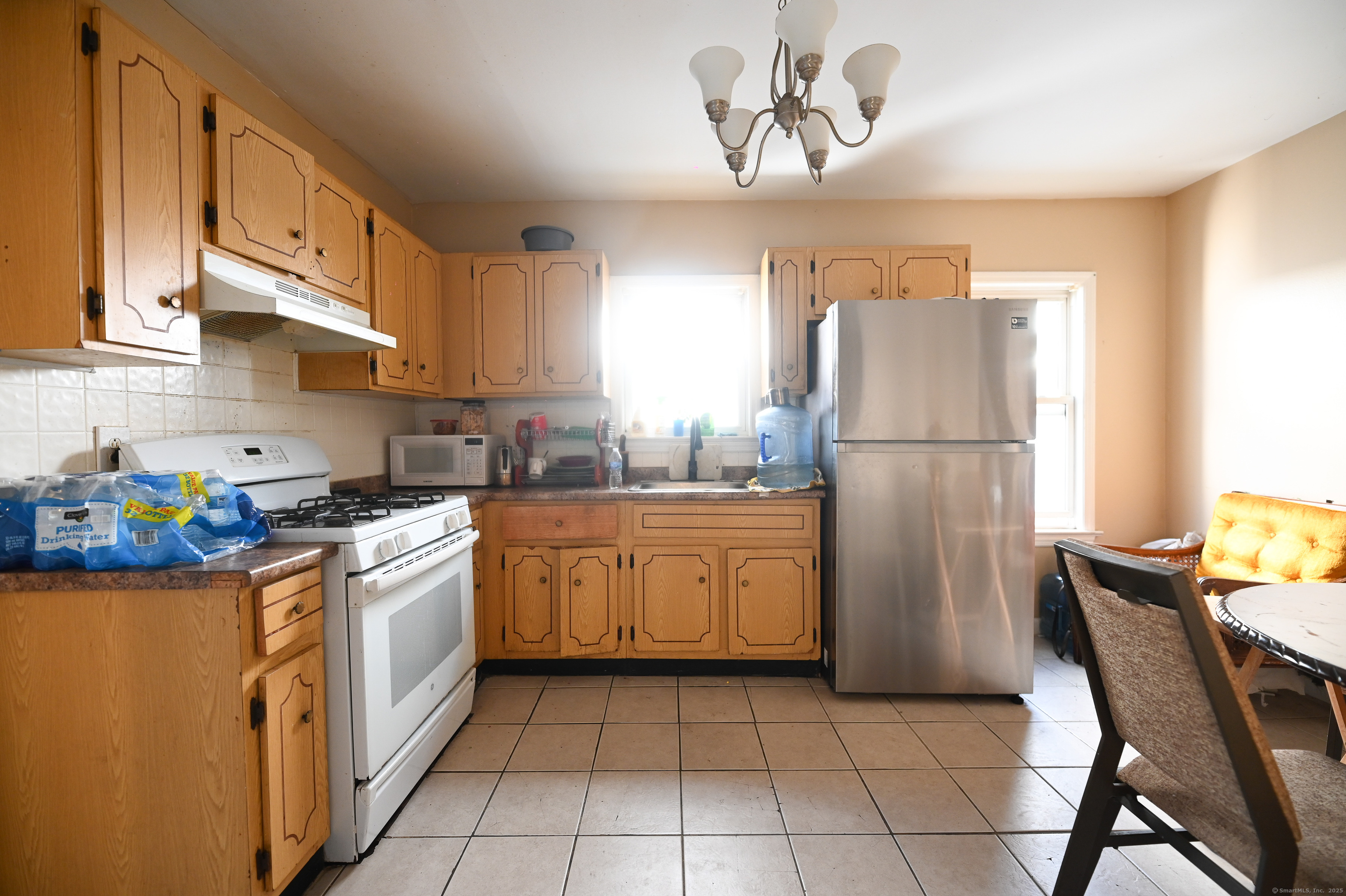 277 Helen Street Bridgeport, CT 06608 - Photo 10 of 19 a kitchen with a refrigerator and a stove top oven