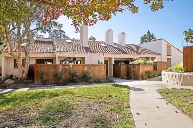 a front view of a house with a garden and yard