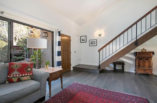 a living room with furniture and a dining table with wooden floor