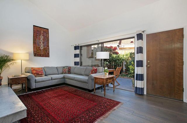 a living room with furniture wooden floor and a large window