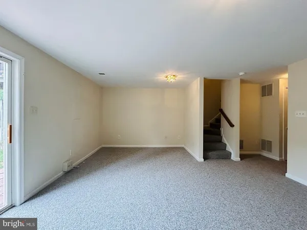 an empty room with a door and wooden floor