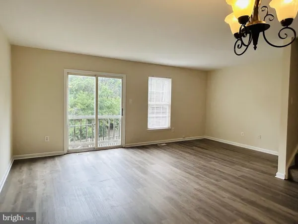 a view of a livingroom with wooden floor and a window
