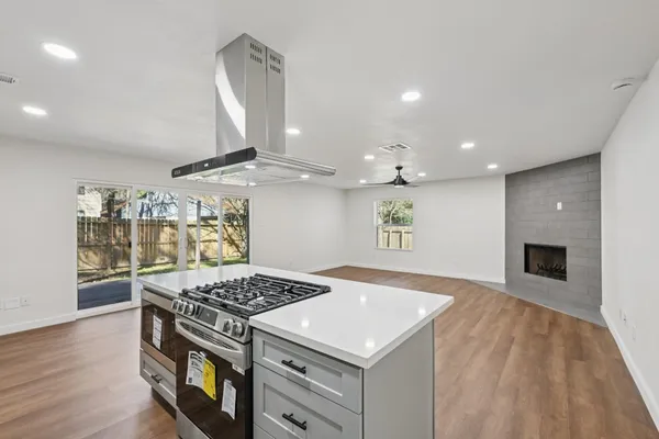 a kitchen with a stove and a wooden floor