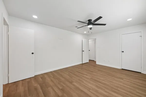 a view of a big room with wooden floor a kitchen space a sink and a window