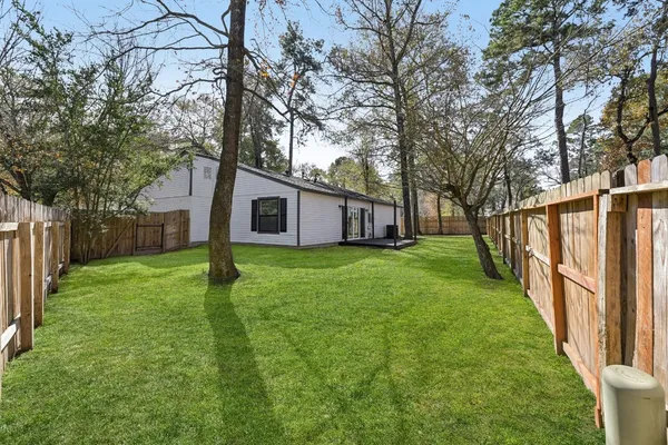 a view of a house with backyard and wooden fence