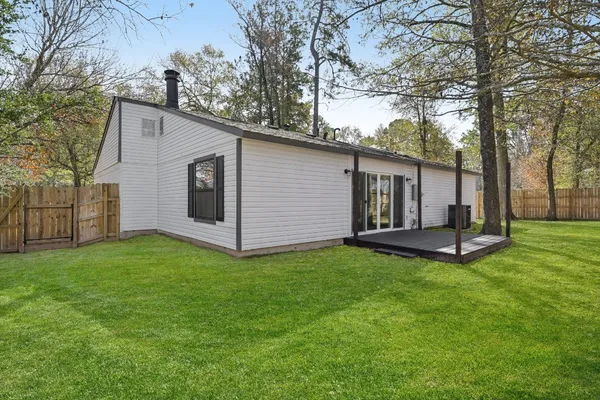 a view of a house with backyard and tree