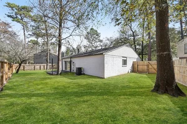 a view of a house with backyard and a tree