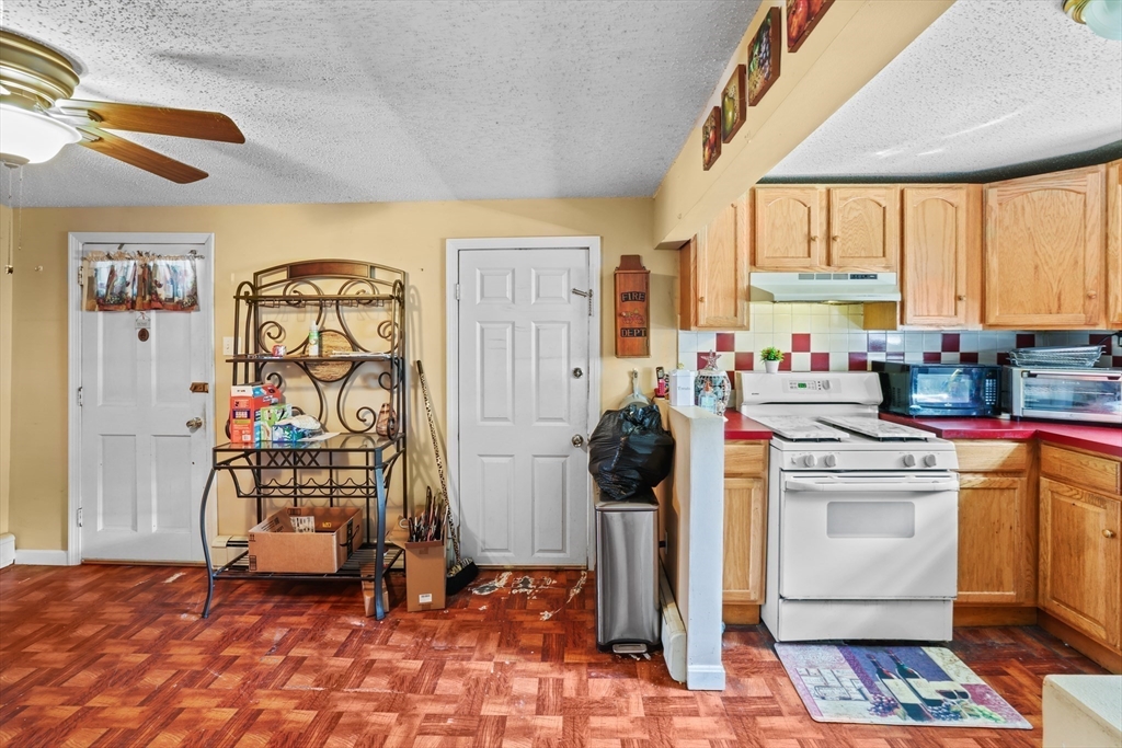 242 Washington Street Fall River, MA 02721 - Photo 11 of 23 a kitchen with stainless steel appliances a stove a sink and a refrigerator