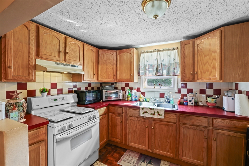 242 Washington Street Fall River, MA 02721 - Photo 9 of 23 a kitchen with stainless steel appliances a stove sink and cabinets