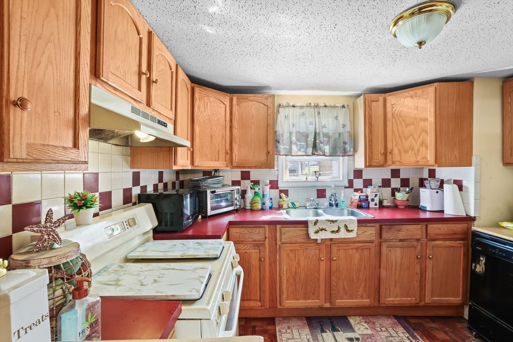 242 Washington Street Fall River, MA 02721 - Photo 10 of 23 a kitchen filled with a window a sink and cabinets