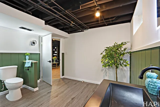 a bathroom with a toilet and a potted plant