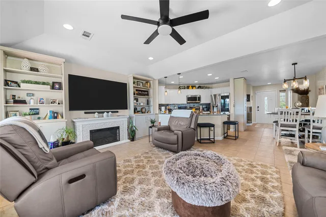 a living room with furniture a flat screen tv and a fireplace