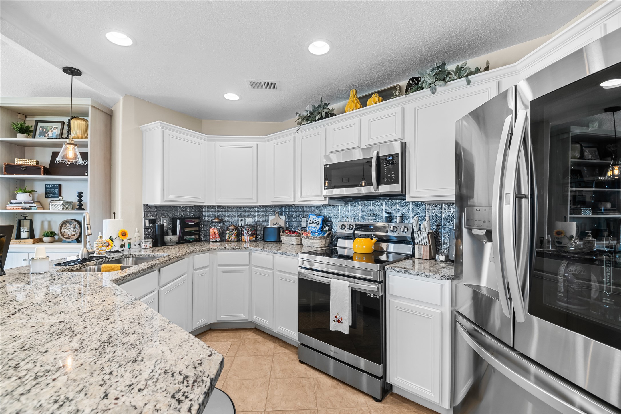 615 28th Street Dickinson, TX 77539 - Photo 9 of 34 a kitchen with stainless steel appliances granite countertop a refrigerator a stove top oven a sink a dining table and chairs