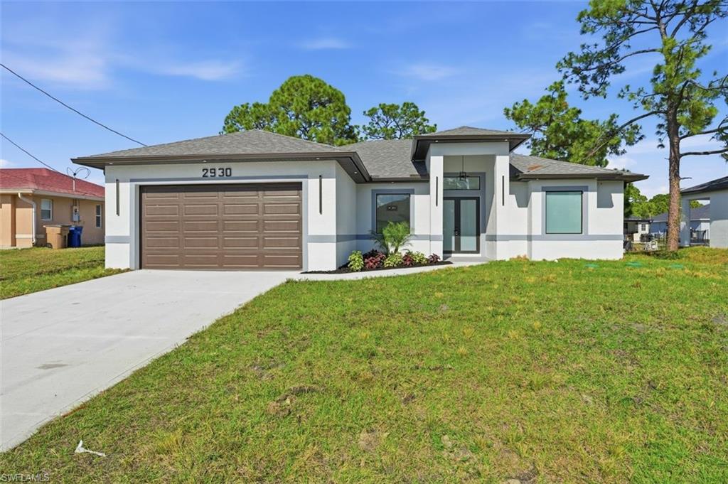 2930 20th Street Southwest Lehigh Acres, FL 33976 - Photo 1 of 43 a front view of a house with a yard and garage