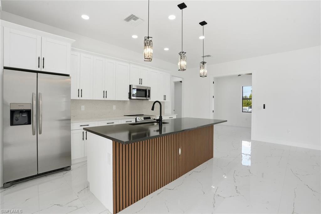 2930 20th Street Southwest Lehigh Acres, FL 33976 - Photo 11 of 43 a kitchen with granite countertop a sink stove and refrigerator