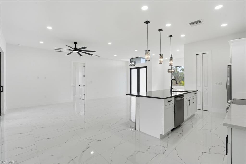 2930 20th Street Southwest Lehigh Acres, FL 33976 - Photo 12 of 43 a kitchen with stainless steel appliances a refrigerator and a sink