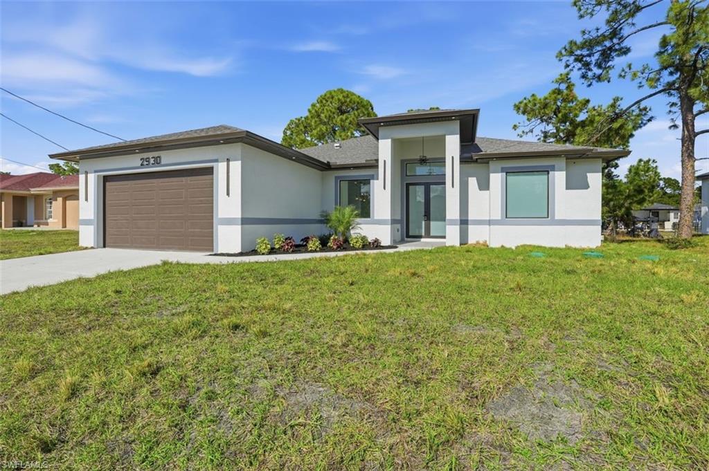 2930 20th Street Southwest Lehigh Acres, FL 33976 - Photo 2 of 43 a front view of a house with a garden and yard