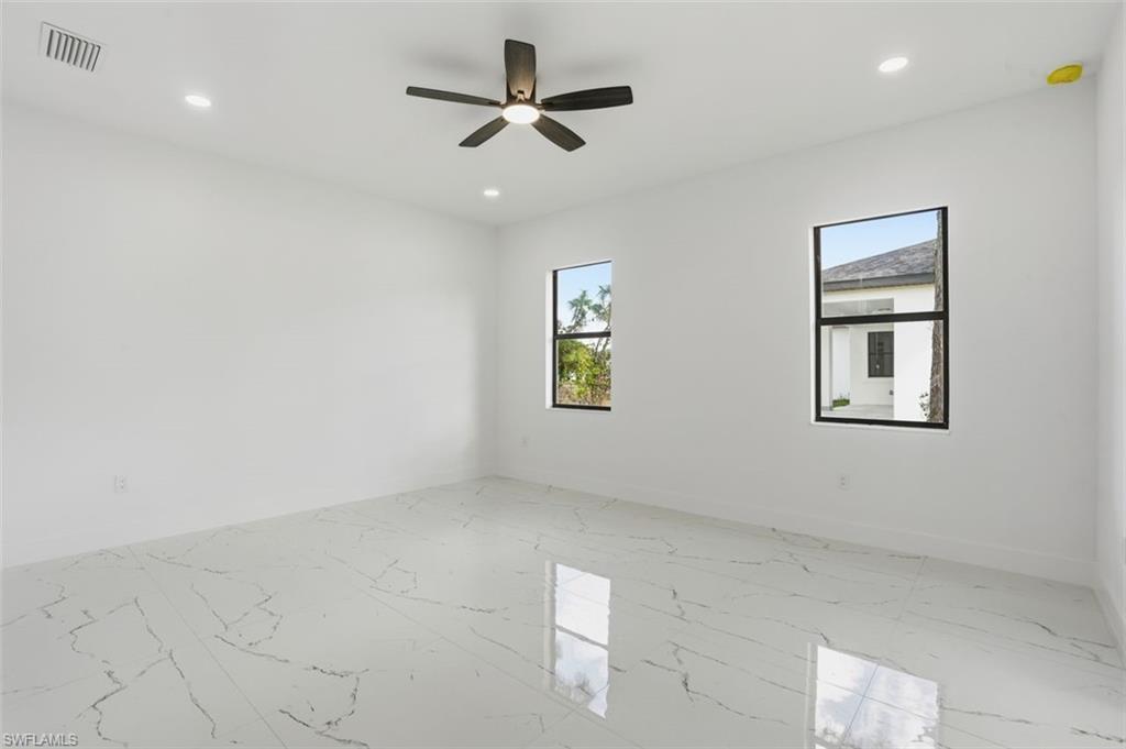 2930 20th Street Southwest Lehigh Acres, FL 33976 - Photo 30 of 43 an empty room with windows and ceiling fan