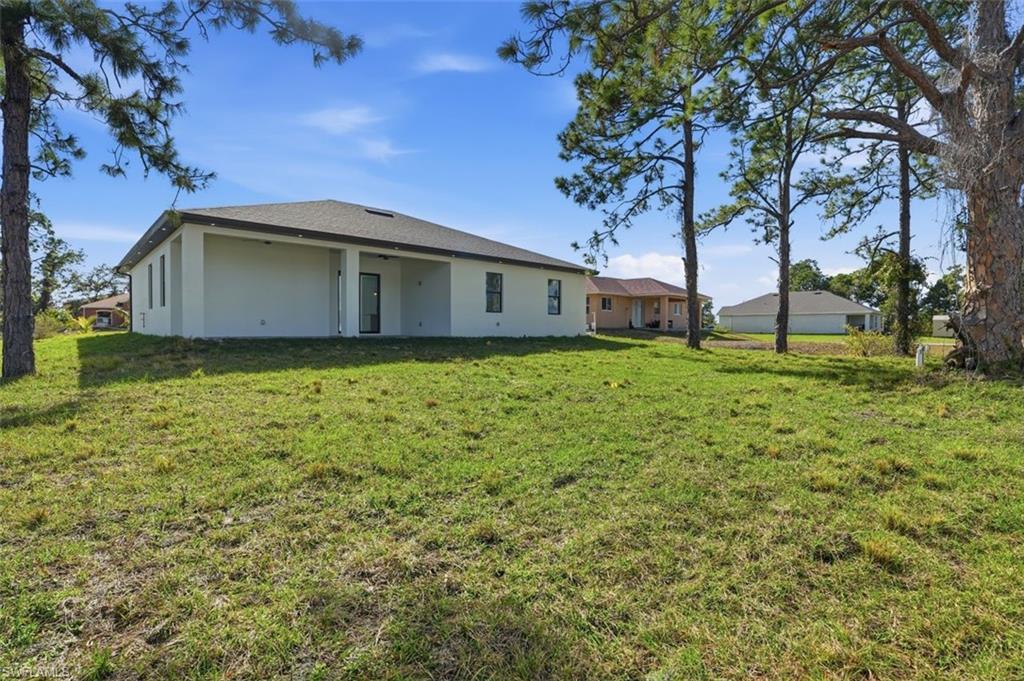 2930 20th Street Southwest Lehigh Acres, FL 33976 - Photo 43 of 43 a white house that has tree in front of it