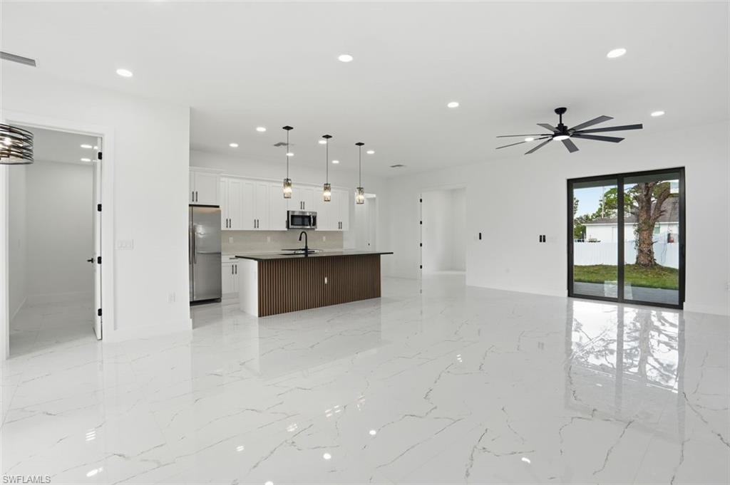2930 20th Street Southwest Lehigh Acres, FL 33976 - Photo 7 of 43 a large white kitchen with a large window stainless steel appliances