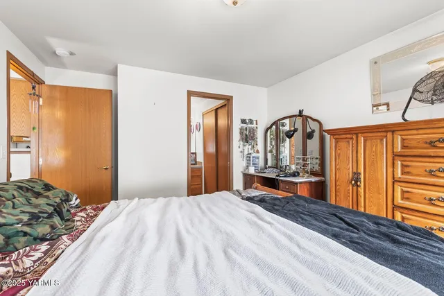 a bedroom with a bed a dresser and mirror