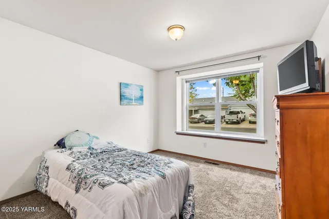 a bedroom with a bed and a painting on the wall