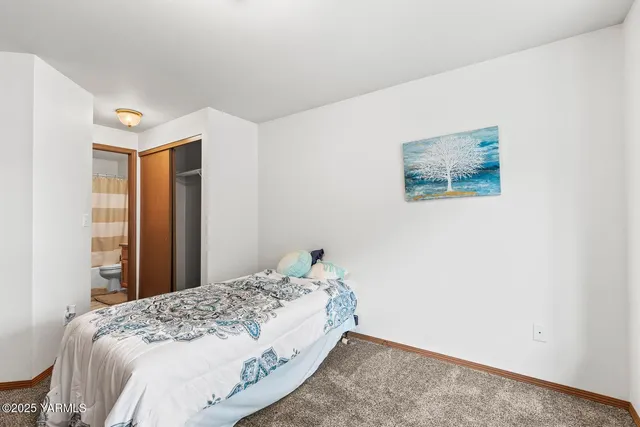 a bedroom with a bed and a painting on the wall