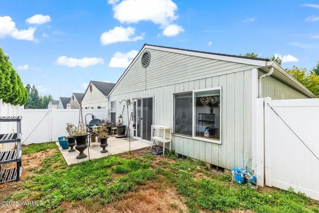 a backyard of a house with table and chairs