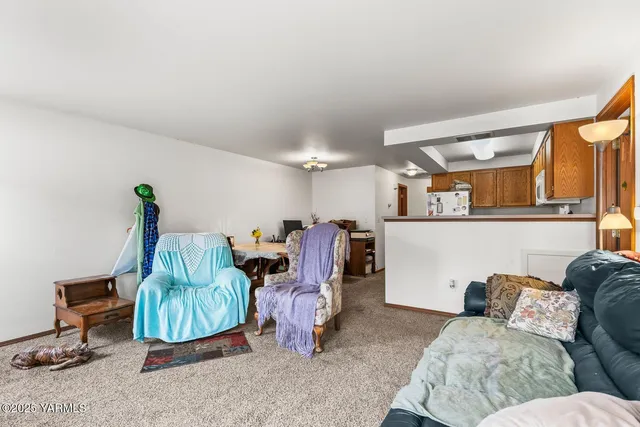 a living room with furniture a rug and white walls