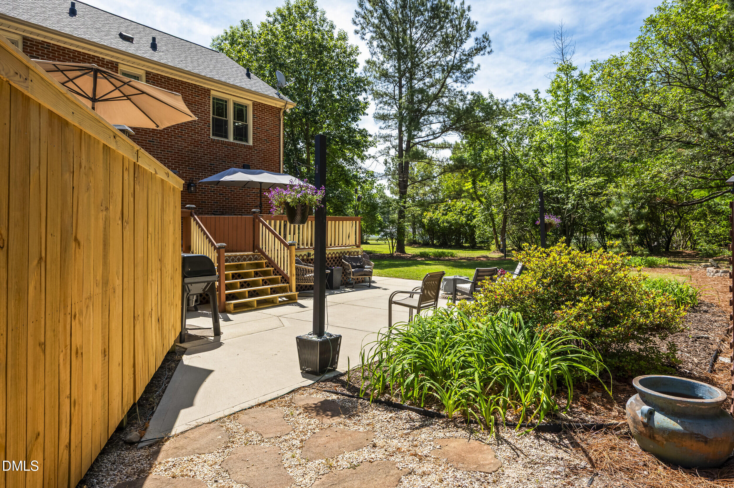4209 Lassiter Road Wake Forest, NC 27587 - Photo 16 of 39 a view of a patio with table and chairs potted plants and large tree