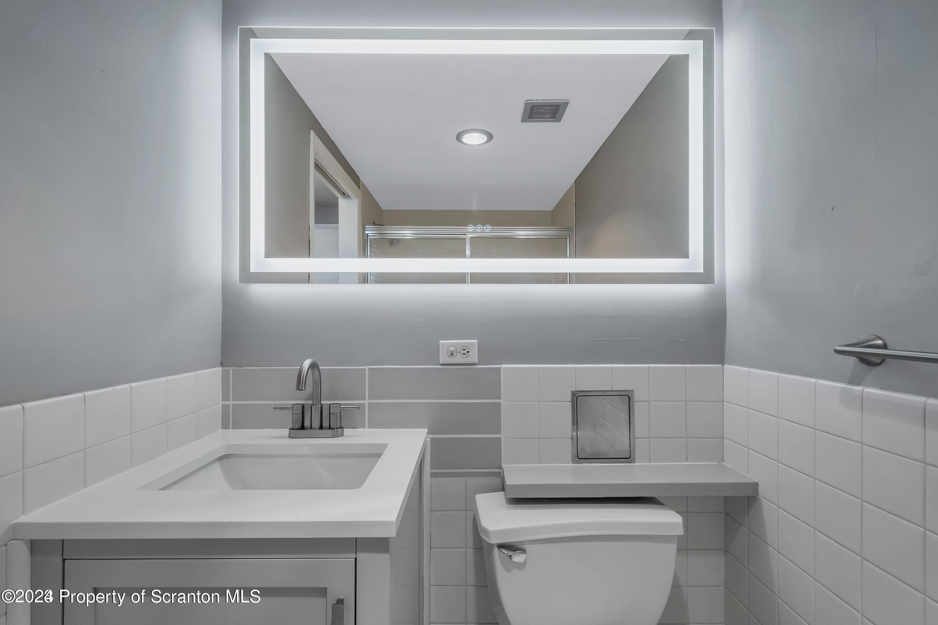 550 Clay Avenue, Unit 9B Scranton, PA 18510 - Photo 8 of 15 a bathroom with a toilet a sink and mirror
