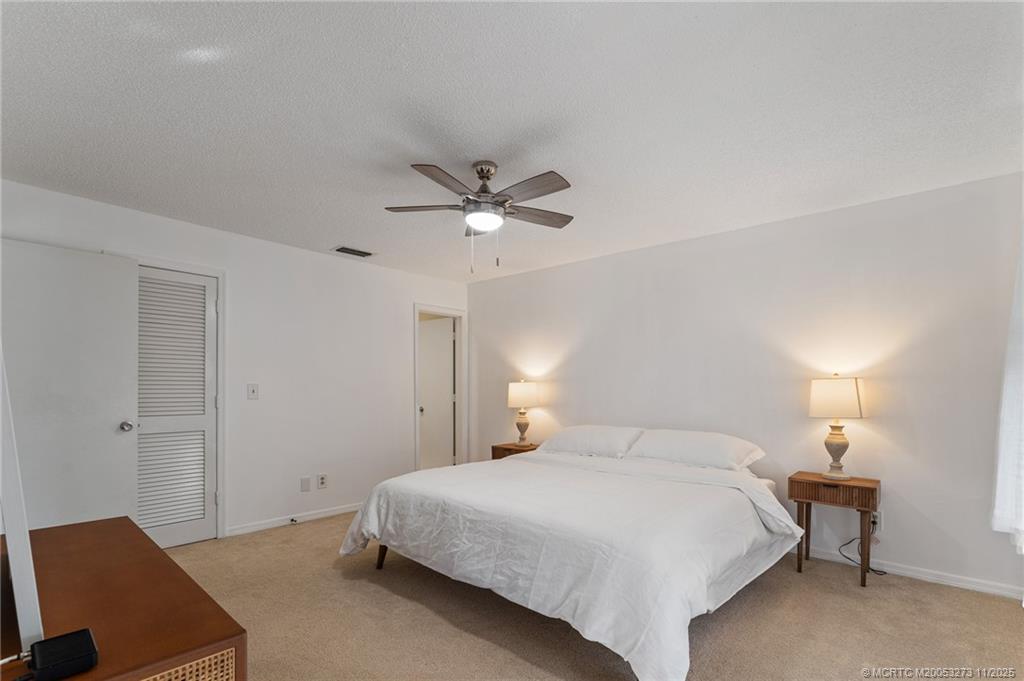 1210 Southeast Parkview Place, Unit 9 Stuart, FL 34994 - Photo 11 of 36 a bedroom with a bed and a chair