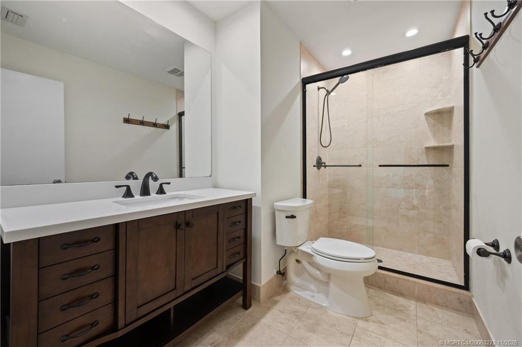 1210 Southeast Parkview Place, Unit 9 Stuart, FL 34994 - Photo 13 of 36 a bathroom with a double vanity sink toilet mirror and shower